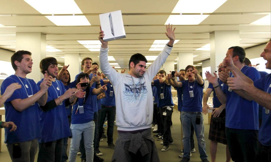Imagen de Albert Llambrich, MacTrompa levantando el iPad de segunda generación en la Apple Store de la Maquinista el día del lanzamiento. MacTrompa esta rodeado de gente que trabaja en Apple con sus caracteristicos polos de trabajo azules por aquella época. 
