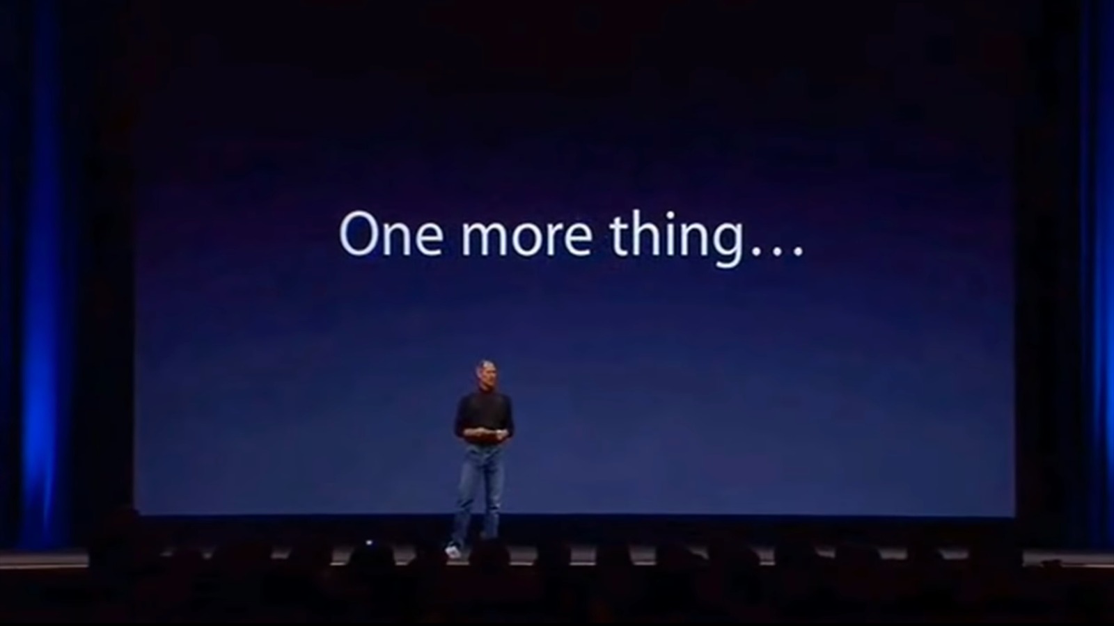 Steve Jobs en el escenario de una de sus presentaciones con la frase " One more thing..." en la pantalla. 