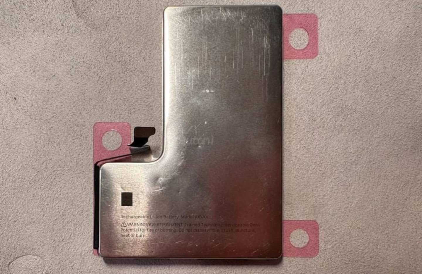Imagen publicada en MacRumors que muestra una batería de acero inoxidable en forma de L para futuros iPhones
