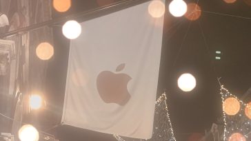 imagen donde se aprecia una bandera blanco y en el centro el logo de la  mordida de Apple