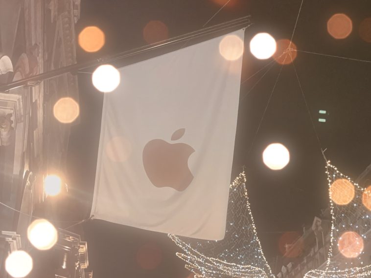 imagen donde se aprecia una bandera blanco y en el centro el logo de la  mordida de Apple