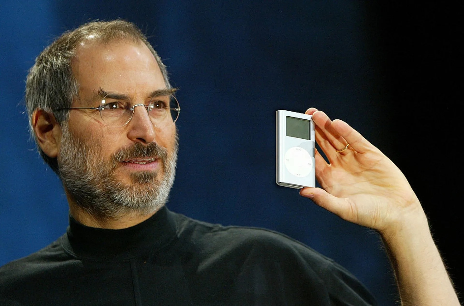 Steve Jobs sujetando en la mano el iPod original en la presentación de 2001